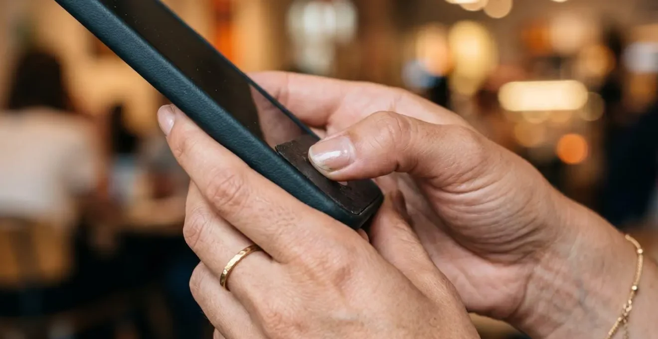Gros plan sur des mains tenant un smartphone en train d'enregistrer une vidéo